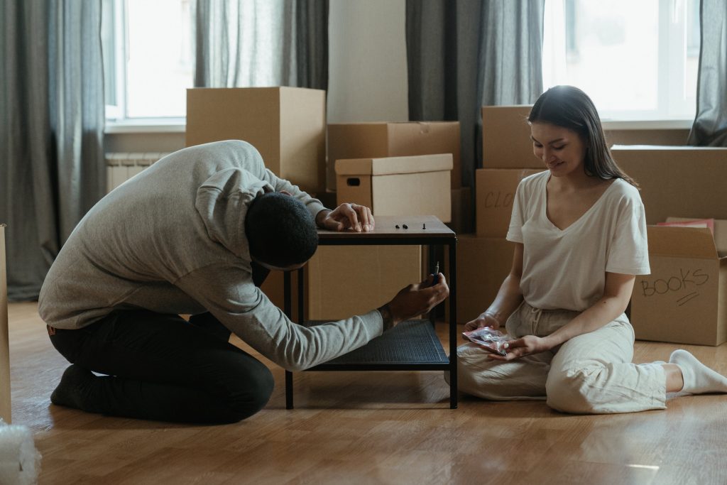 "A man using tools to dismantle furniture by using Disassembly Planning Efficiency."