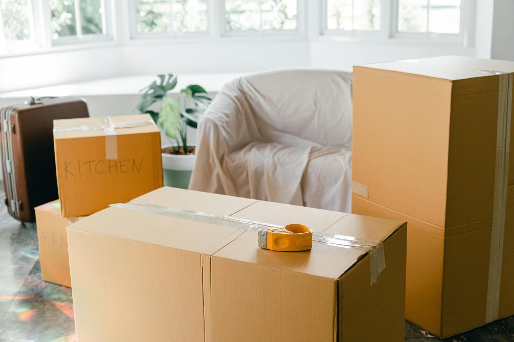 "Efficient moving: Packing clothing into boxes using room-by-room checklist."