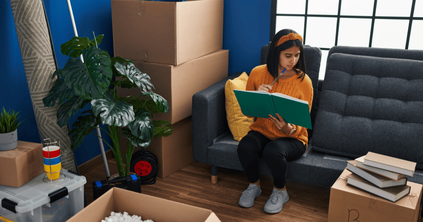 A student sitting on a couch and making a checklist. 