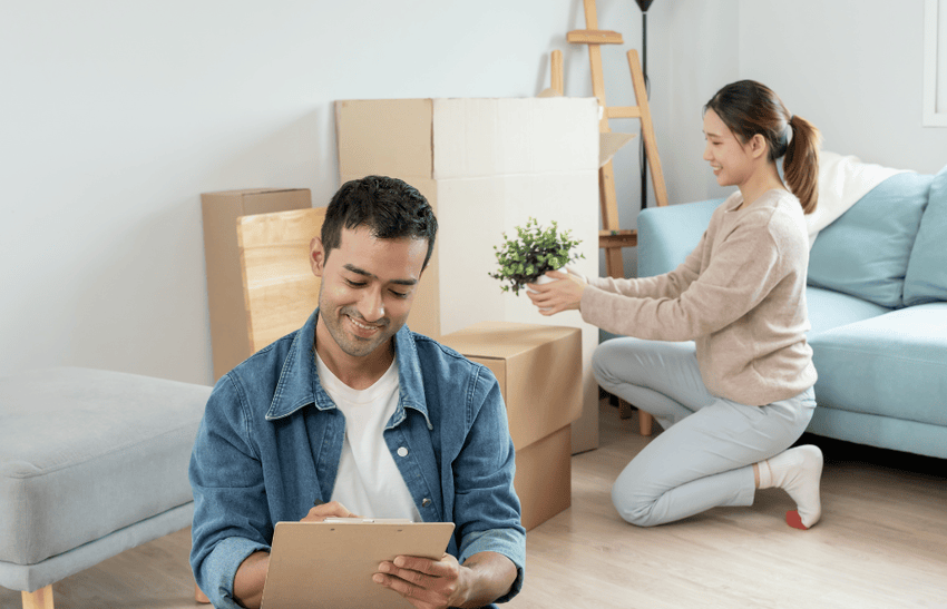 A woman putting things in a box and a man is making a checklist, depicting the Moving Checklist for London Ontario Residents.